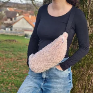femme adossé contre un arbre pour une banane souple en moumoute rose avec une anse réglable noire